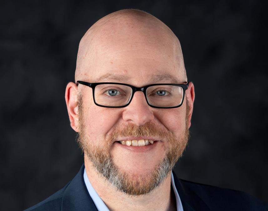 Marty Lang, a communication professor, smiles in a head shot