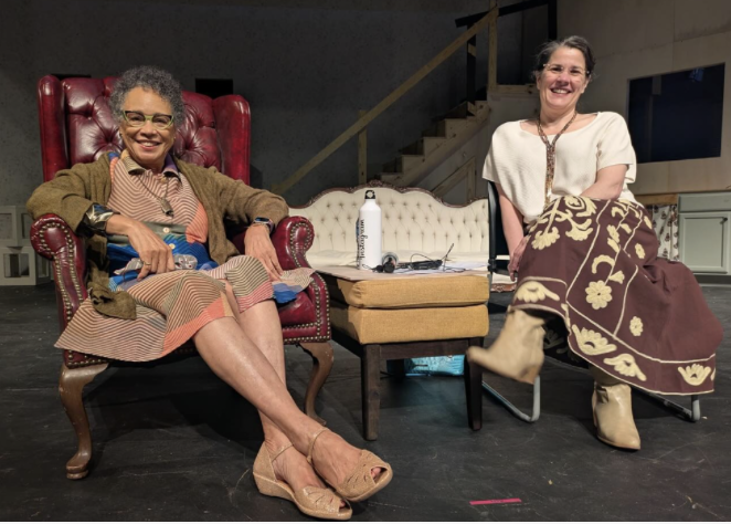 Melanie Harris and Myrna Colley-Lee sit on the McComas Hall Theatre Stage and smile at the camera